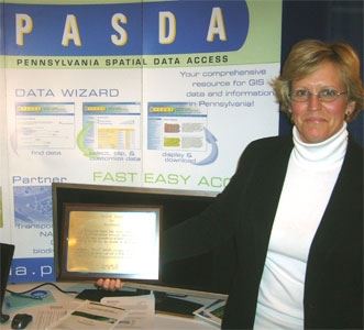maurie kelly holding excellence award at PASDA booth